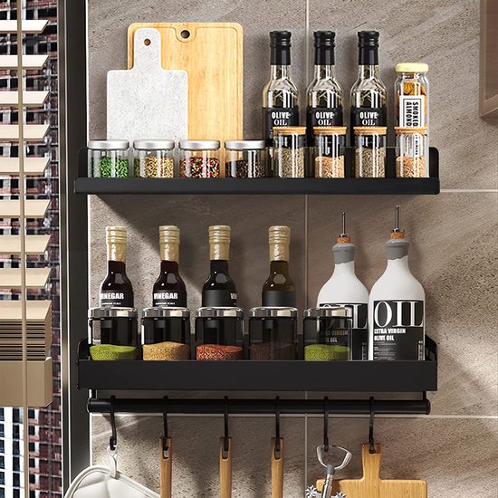 Zwart wandmontage kruidenrek met glazen potjes, flessen olijfolie en snijplanken.