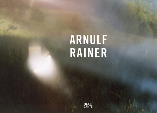 Boekomslag met tekst 'ARNULF RAINER' en 'HATJE CANTZ' op een wazige, zonnige achtergrond.