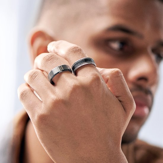 Dichtbij weergave van een zilverkleurige ring met geborsteld middenstuk en een andere ring met zwart rasterpatroon.