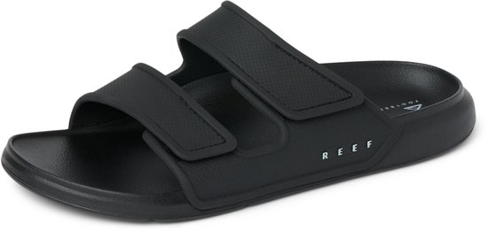 Zwarte Reef slipper op een witte achtergrond, met 'REEF' en 'FOOTBED' tekst op de voetbed.