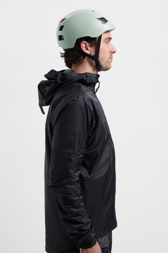 Man in profiel, met een zwarte fietsjas en een lichtgroene helm.