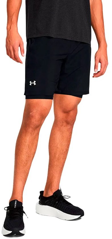 Man in zwart sportshirt en zwarte sportbroek met dubbele laag, 7 inch binnenbeenlengte, met sneakers.