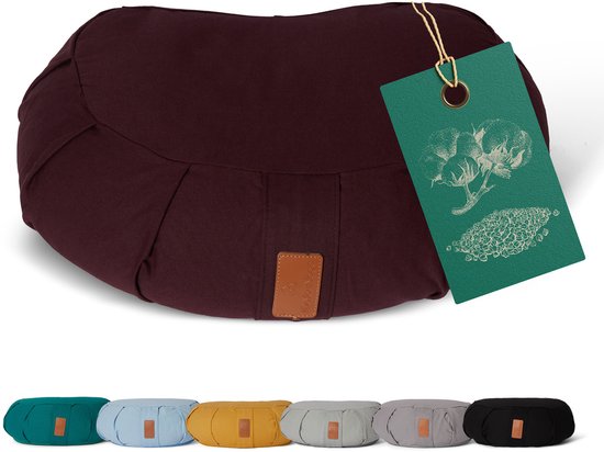 Een bruin meditatiekussen met een groen label waarop katoen is afgebeeld. Onderaan zijn 7 kussens in verschillende kleuren te zien.