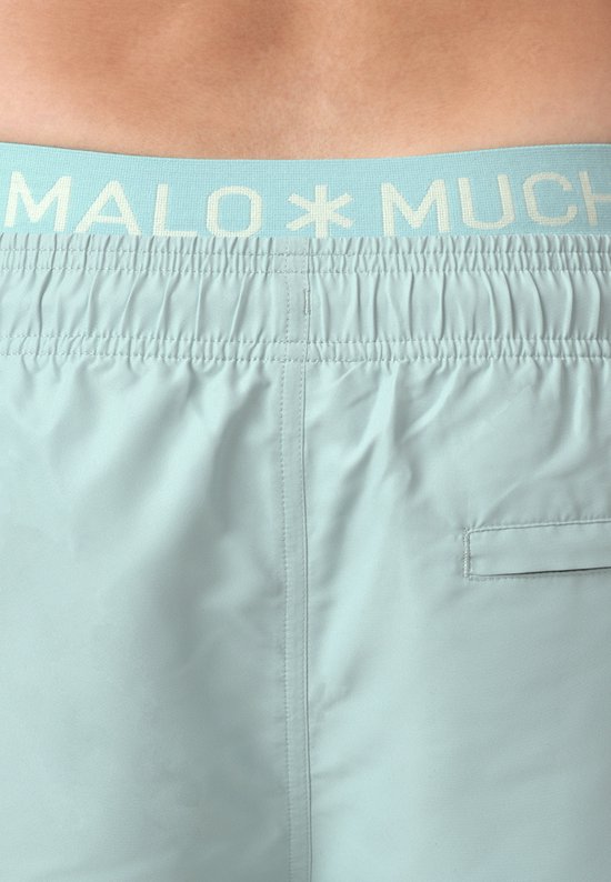 Detail van de achterkant van een lichtblauwe zwembroek met elastische tailleband met logo.