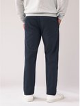 Achteraanzicht van een model met een marineblauwe chinobroek en grijze trui.