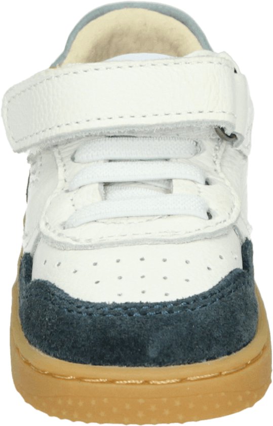 Vooraanzicht witte leren sneaker met donkerblauwe suède details en bruine zool. Klittenbandsluiting en veters.