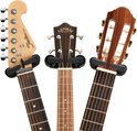 Close-up van de koppen van drie instrumenten: elektrische gitaar, ukulele en klassieke gitaar.