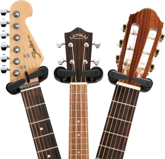 Close-up van de koppen van drie instrumenten: elektrische gitaar, ukulele en klassieke gitaar.