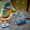 Un garçon construit le LEGO Fortnite Battle Bus, avec des instructions sur une tablette.