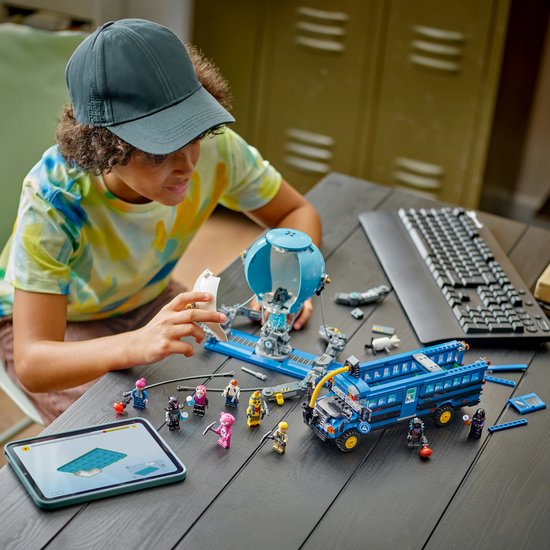 Un garçon construit le LEGO Fortnite Battle Bus, avec des instructions sur une tablette.