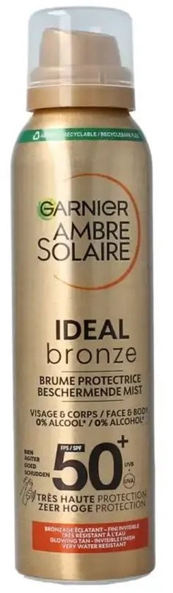 Gouden spuitbus Garnier Ambre Solaire Ideal Bronze beschermende mist SPF50+ op witte achtergrond.