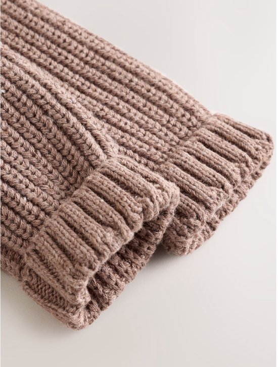Detail van de mouw met geribbelde boorden van een bruin gebreid babyvestje.