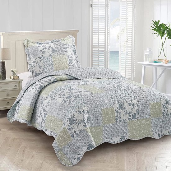 Gedessineerde quilt met patchwork in blauw en groen, met bloemenprints en ruitpatronen. Gekartelde rand en bijpassende kussensloop.
