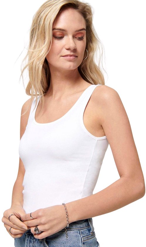 Close-up van een vrouw met een witte tanktop met spaghettibandjes, spijkerbroek en ringen.