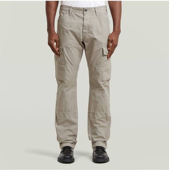 Le mannequin porte un pantalon cargo gris clair avec quatre poches cargo, deux sur les côtés et deux sur le devant des jambes.