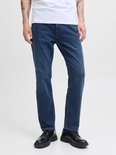 Jonge man, close-up van de donkerblauwe jeans, met zwarte schoenen.