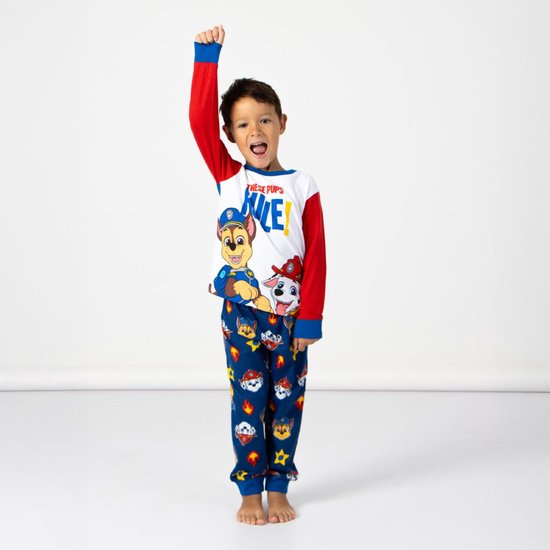Jongen met gebalde vuist omhoog, in blauwe pyjamabroek met Paw Patrol-print en rood-wit shirt.