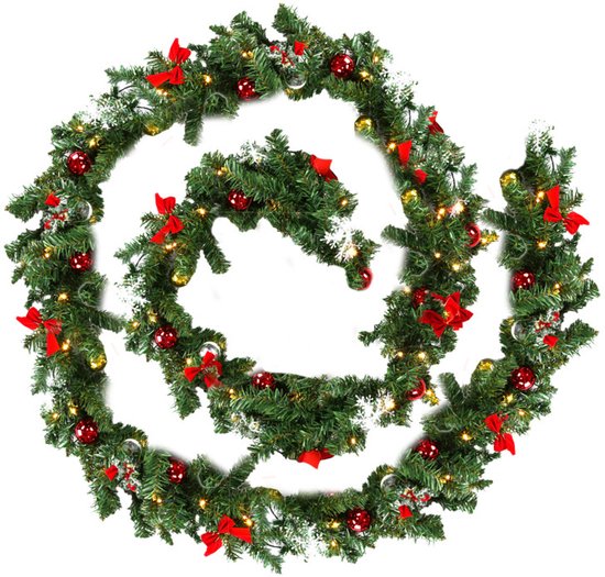 Groene kerstguirlande met rode strikken, rode en gouden ballen en twinkelende lampjes.