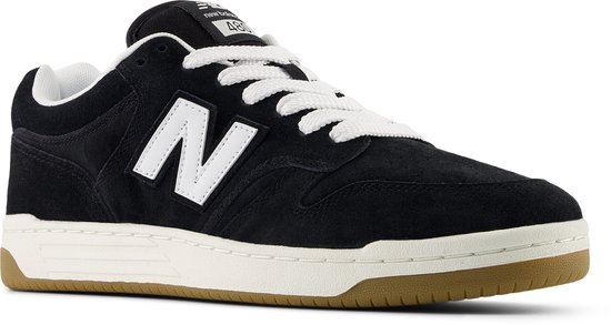 Zwarte suède New Balance sneakers met witte N-logo's, witte veters en bruine zool.