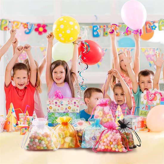 Kinderen met ballonnen op een verjaardagsfeestje, met op de voorgrond stapels gekleurde snoepjes in organzazakjes.