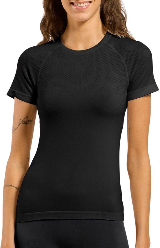 Vrouw draagt zwart sportshirt met korte mouwen, subtiele dot-print en logo linksonder.