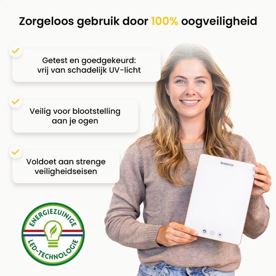 Vrouw met blonde haren houdt een witte BrellaVio daglichtlamp vast. Tekst: Zorgeloos gebruik door 100% oogveiligheid.