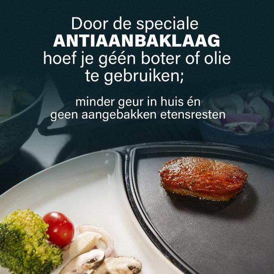 Een stuk vlees wordt gebakken op een zwarte bakplaat met antiaanbaklaag. Geen boter of olie nodig.