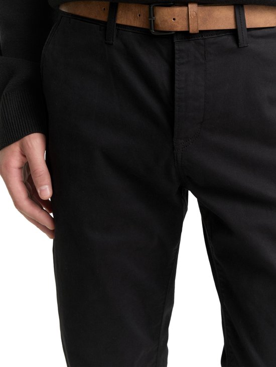 Zwarte chino met een bruine suède riem.