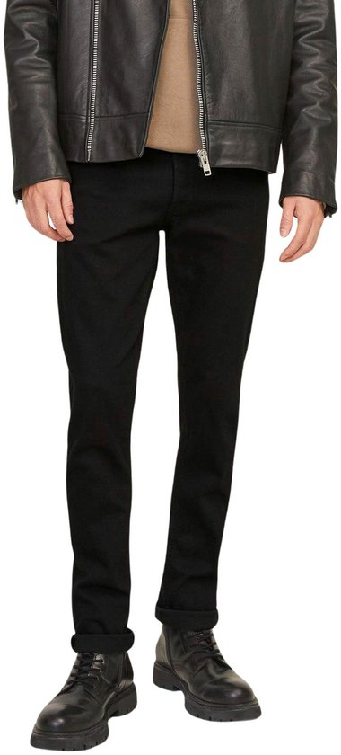 Man in een zwarte skinny jeans, zwarte leren jas en zwarte laarsjes.