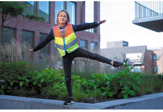 Meisje met bril draagt een WOWOW veiligheidshesje met rits, geel, oranje, groen en reflecterende banen, terwijl ze balanceert.