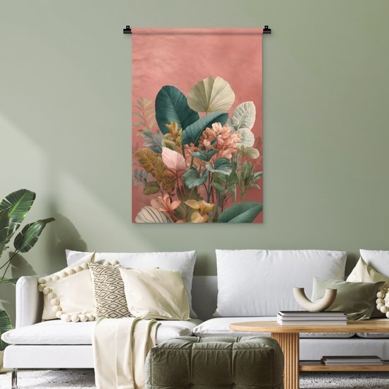 Een wandkleed met tropische bladeren in groen-, crème- en roze tinten, hangend in een woonkamer met een witte bank en fauteuils.