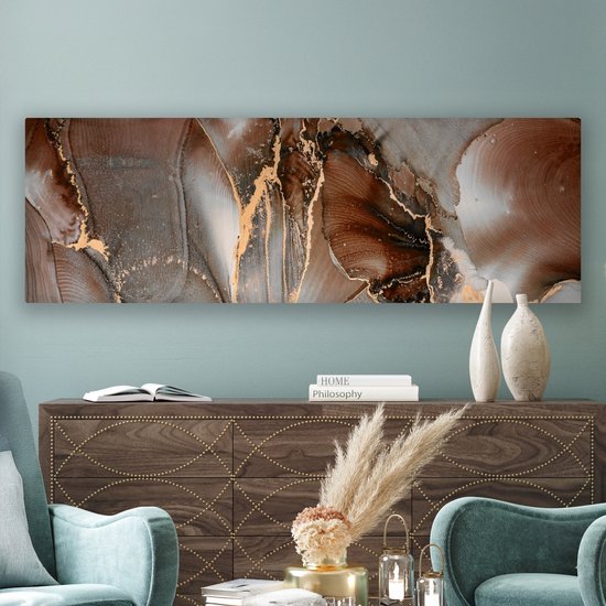 Abstract canvas met bruine, grijze en gouden marmerlook patronen, boven een houten kast in een woonkamer.