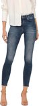 Model in witte blouse en donkerblauwe skinny jeans met rafelige zoom.