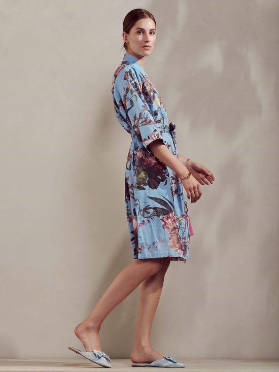 Model, zijaanzicht, in blauwe kimono met bloemenprint en gevlochten tailleband.