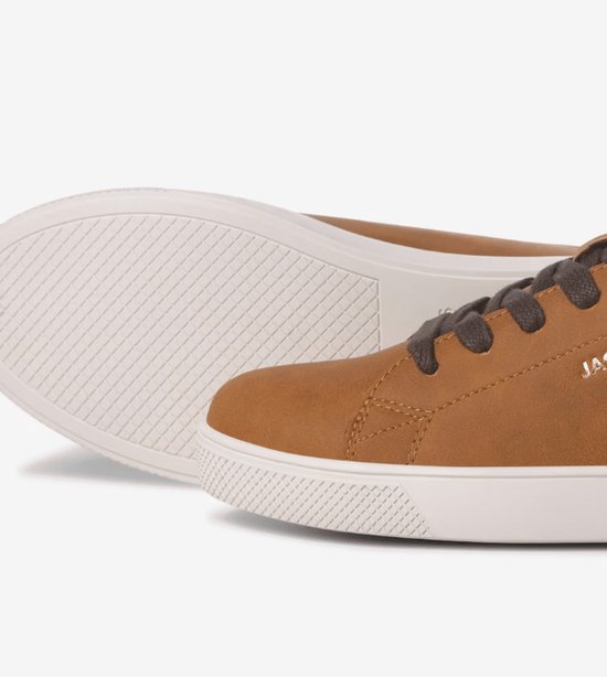 Close-up van de zool en zijkant van een bruine leren Jack & Jones sneaker met witte zool.