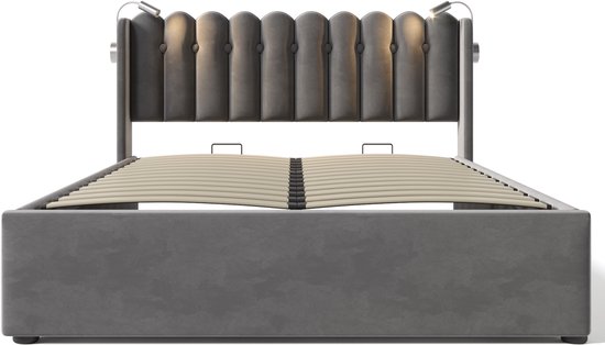 Grijze fluwelen bedombouw met een capitonnerde hoofdbord met ingebouwde leeslampjes, zonder matras.