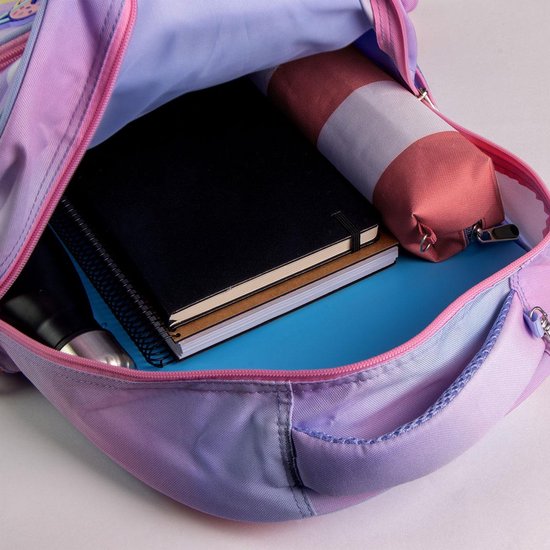 De binnenkant van een roze en paarse rugzak met een zwart notitieboek, een potloodcase en een waterfles.