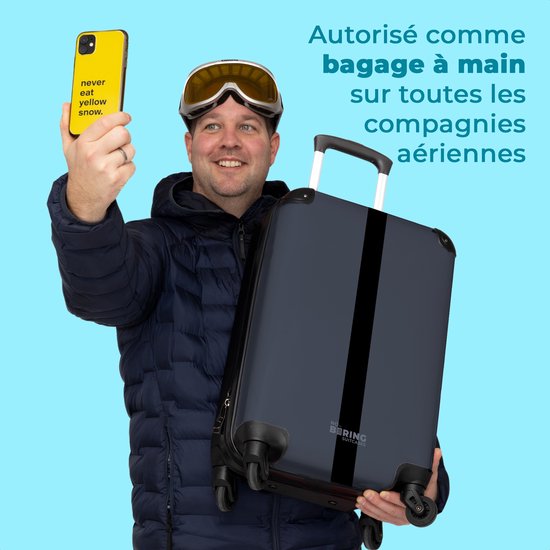Man in skikleding met skibril houdt blauwe koffer vast. Hij neemt selfie met telefoon. Tekst: 'Autorisé comme bagage à main sur toutes les compagnies aériennes'.