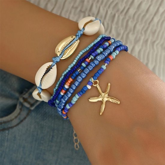 Blauwe armbanden met schelpen, gouden schelp- en zeesterbedeltjes.