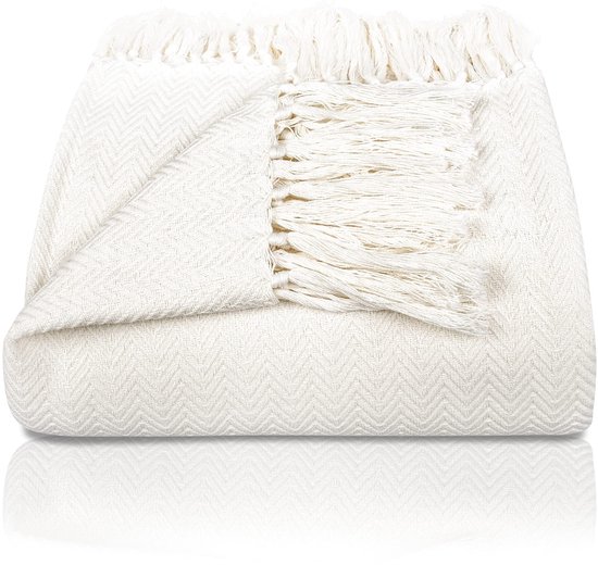 Gevouwen off-white katoenen sprei met visgraatpatroon en franjes.