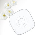 Een vierkante, transparante bloempot met een binnenpot, naast vier witte orchideeën.