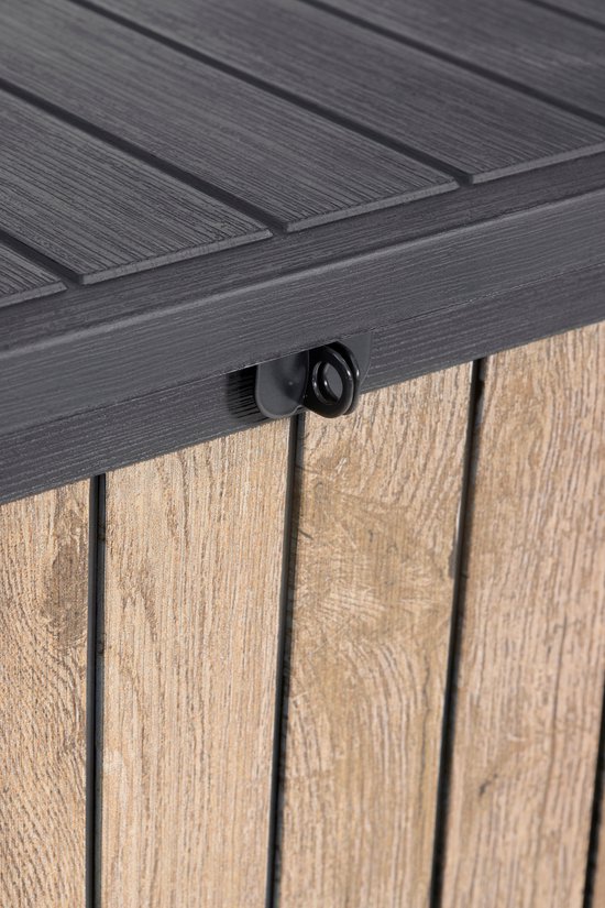 Detail van het zwarte slotmechanisme op de houten opbergbox.