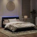 Cadre de lit noir avec tête de lit rembourrée et éclairage LED, fait dans une chambre.