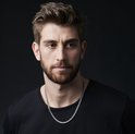 Model met een zilverkleurige schakelketting om zijn nek.