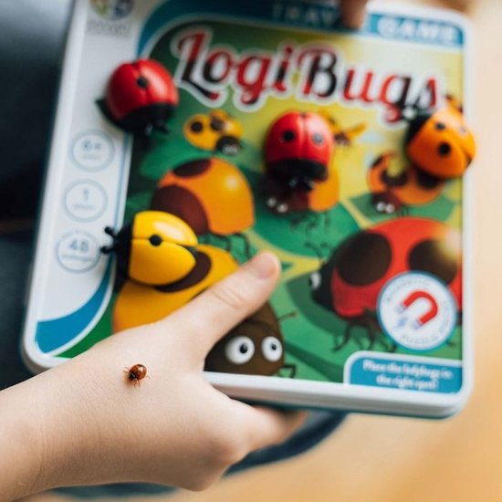 Gros plan de la boîte de jeu LogiBugs tenue par un enfant, avec une petite coccinelle sur la main.
