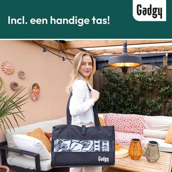 Une femme porte un grand sac noir avec le logo Gadgy, avec un tapis d'extérieur partiellement visible.
