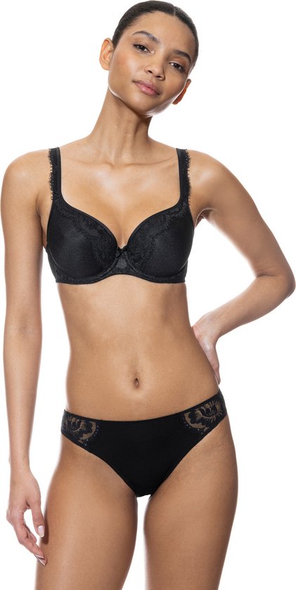 Model draagt een zwarte kanten bh en bijpassende slip. De bh heeft kanten details op de cups.