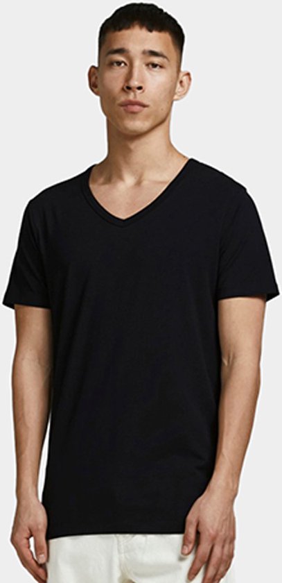 Man met zwart T-shirt met V-hals en witte broek.