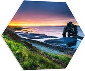 PVC Schuimplaat Hexagon - Enorme Rots in de Zee bij de Bergen tijdens Zonsondergang - 60x52.2 cm Foto op Hexagon (Met Ophangsysteem)