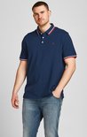 Man draagt donkerblauw poloshirt met rode en witte strepen op kraag en mouwen. Rood '&' logo.